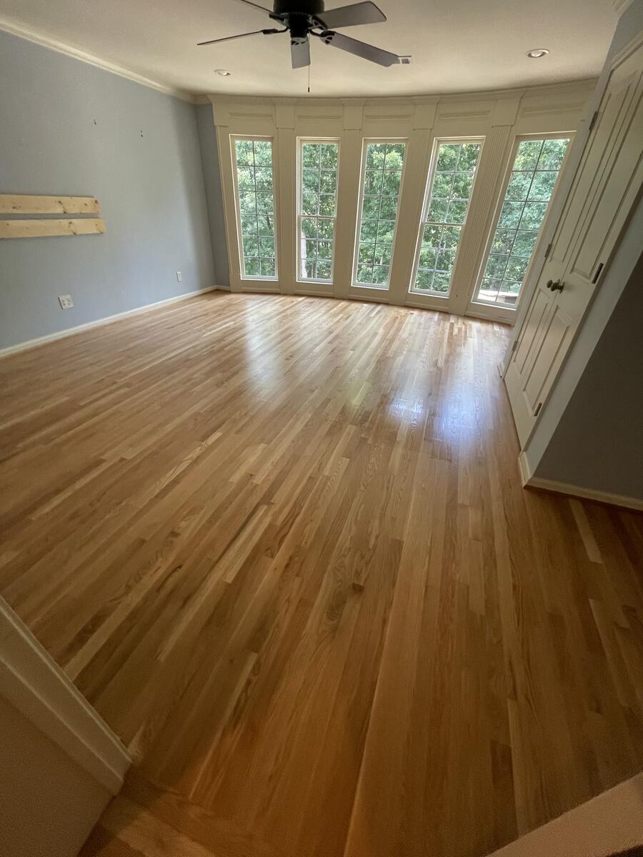 Light natural hardwood floor with tall windows